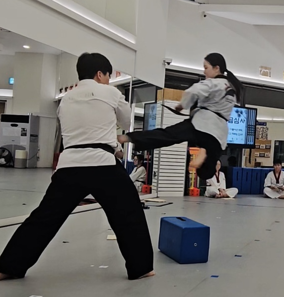 Chaeyoon performing a jumping kick during a Taekwondo demonstration