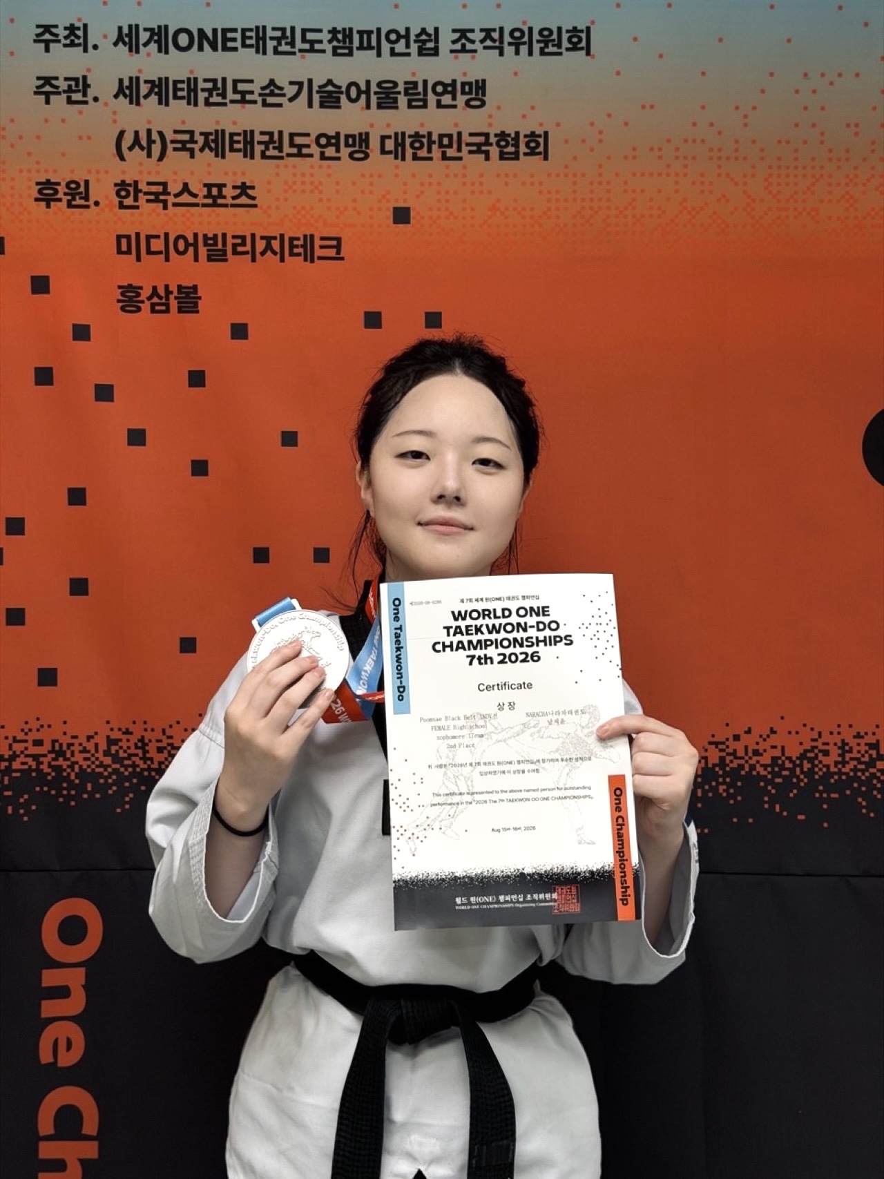 Chaeyoon holding her 2nd place medal and certificate at the 7th World ONE Taekwon-Do Championships 2026